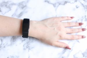 someone's hand and arm while wearing a black sports watch